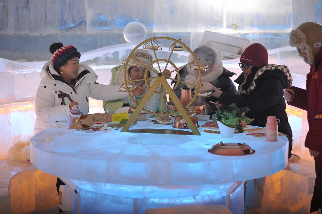2024年1月10日晚,哈尔滨冰雪大世界内,一些南方游客正在冰屋内品尝着热气腾腾的火锅。 2024年1月10日晚,哈尔滨冰雪大世界内,一些南方游客正在冰屋内品尝着热气腾腾的火锅。